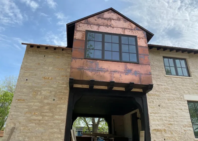 Copper metal panel facade on a stone building for Skylight Installation in Homeland