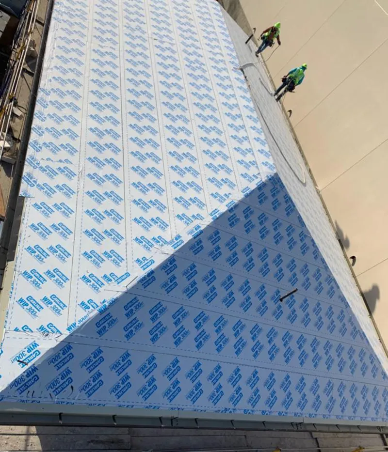 Professional roofers installing underlayment on a metal roof in Homeland